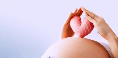 Femme enceinte tenant un coeur sur son ventre